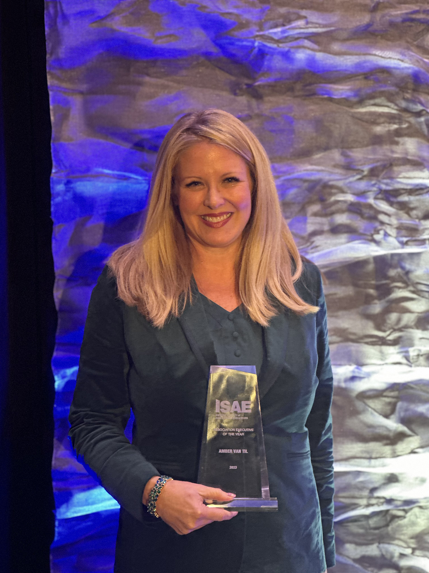 photo showing Amber Van Til posing with the 2023 Association Executive of the Year award